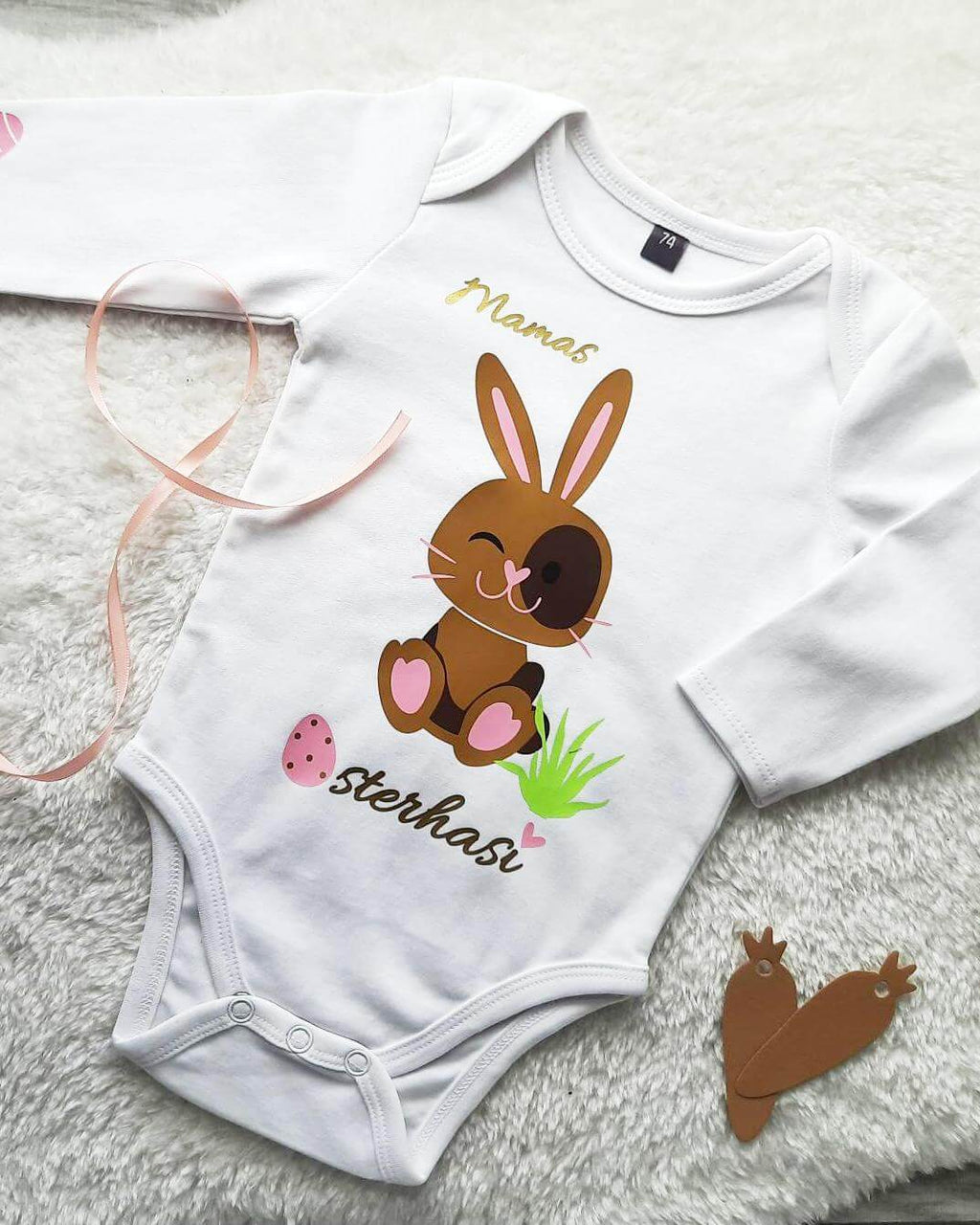Flatlay weißer Babybody mit Osterhase für Ostern in hellbraun und rosa Eier, mit gold metallic Effekt, Mamas Osterhasi