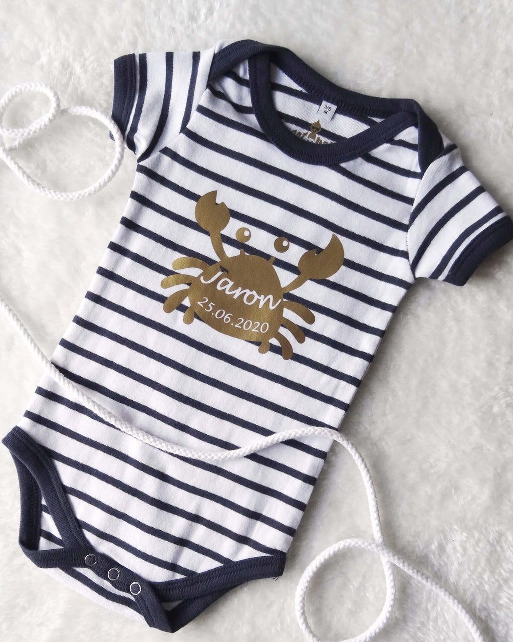 Flatlay Babybody geringelt mit goldenem Aufdruck Krabbe mit Name zur Geburt