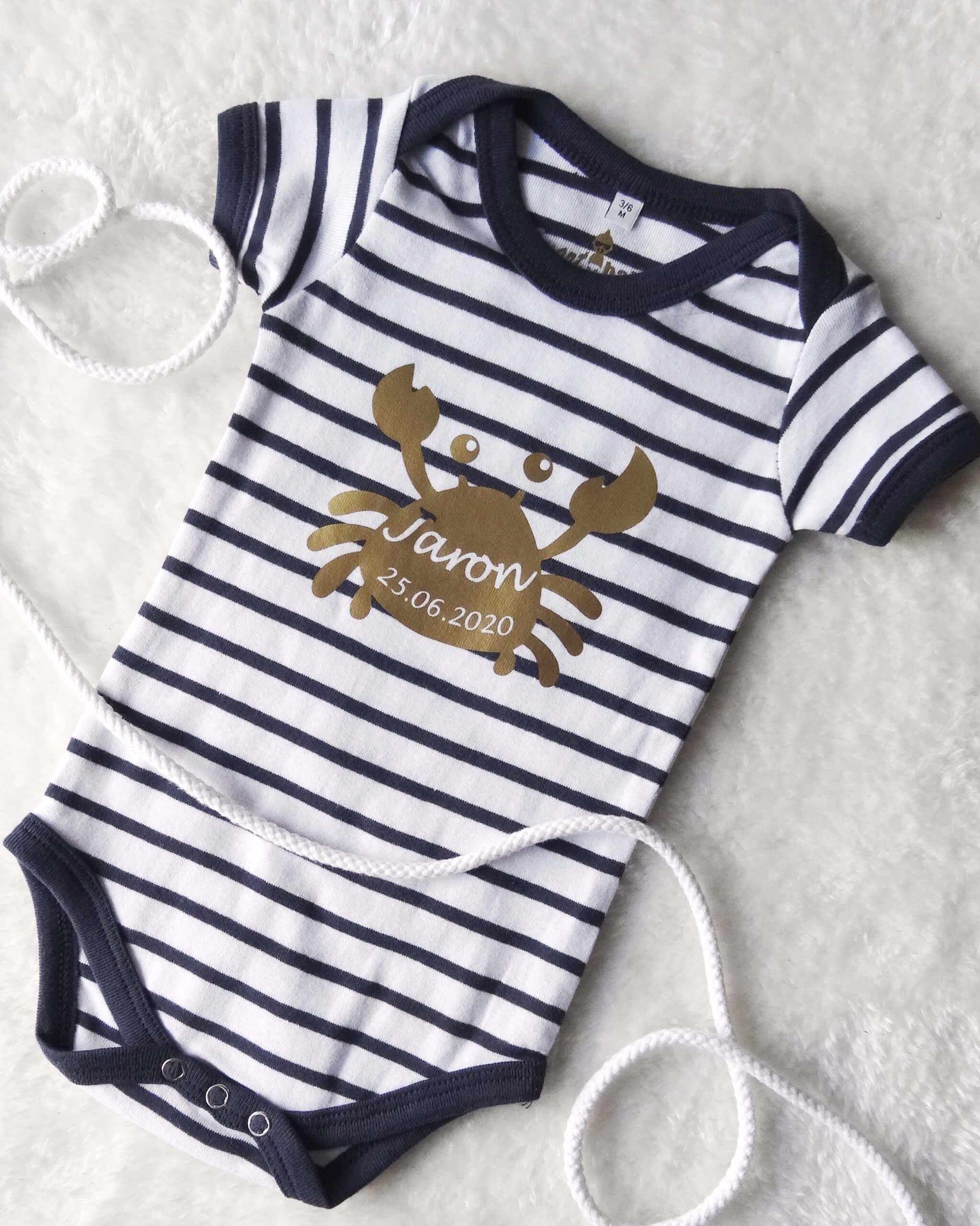 Flatlay Babybody geringelt mit goldenem Aufdruck Krabbe mit Name zur Geburt