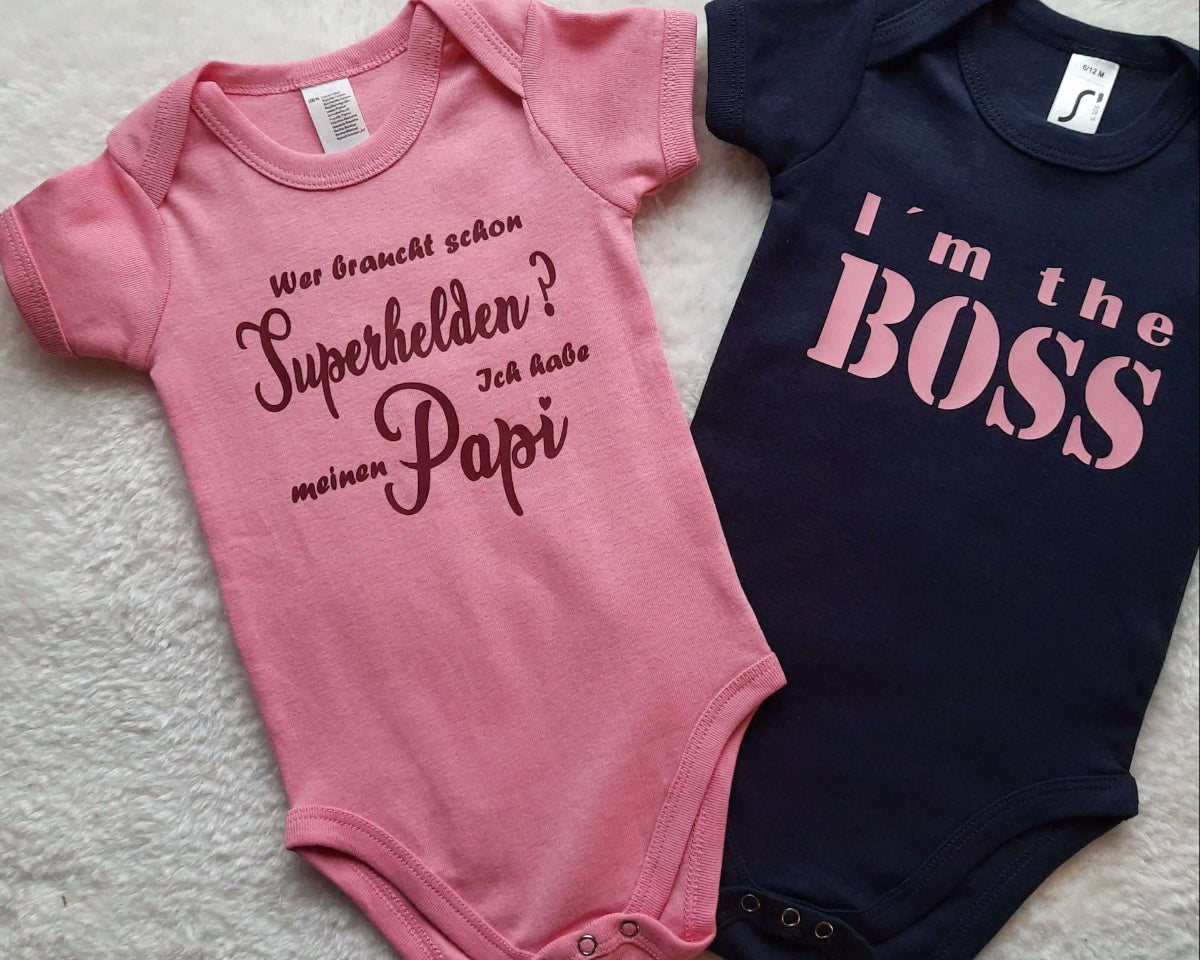 Flatlay zwei Baby Bodys von Smartbabies, Boss und Papa Superheld