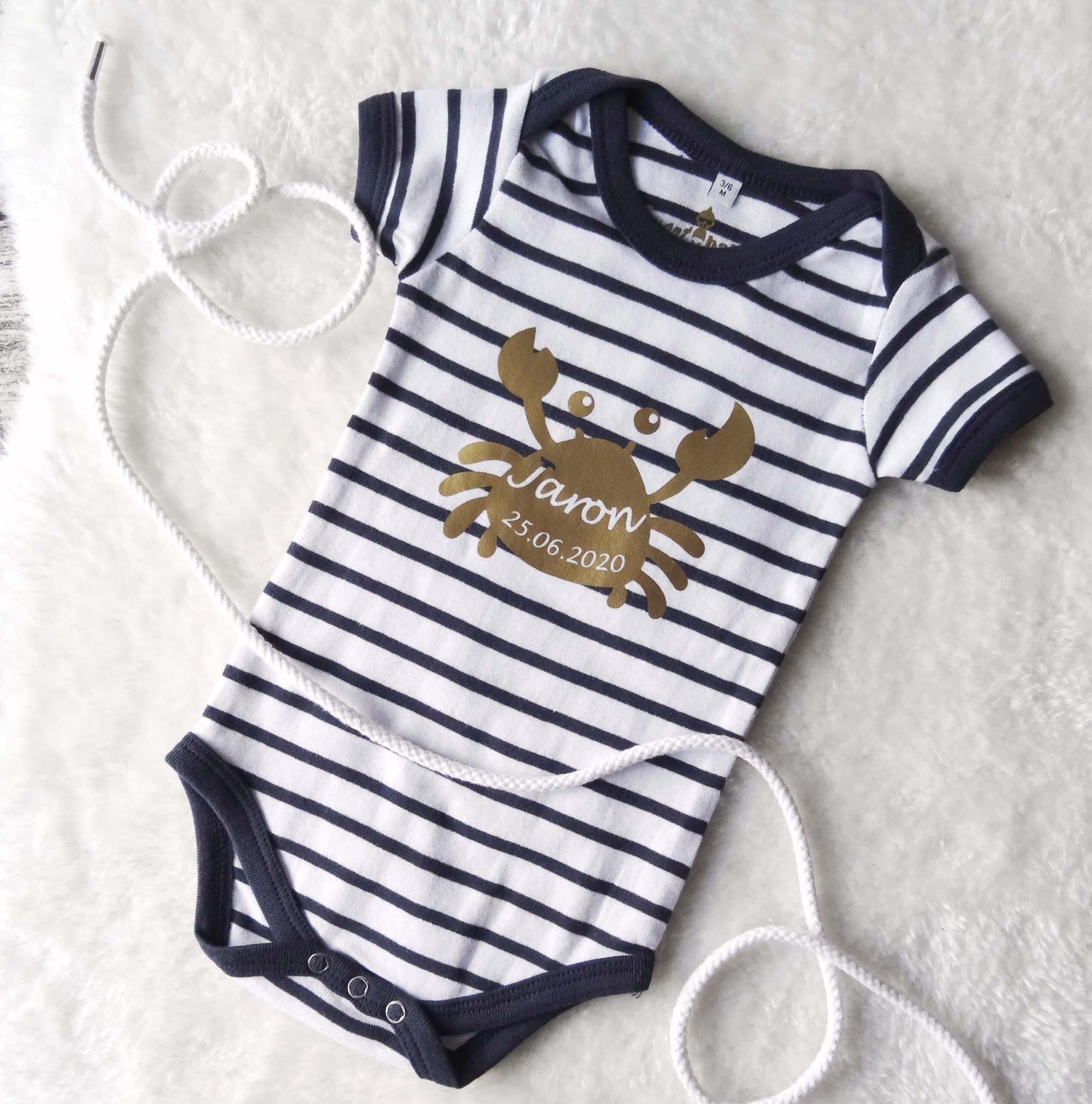 Flatlay Babybody geringelt mit goldenem Aufdruck Krabbe mit Name zur Geburt