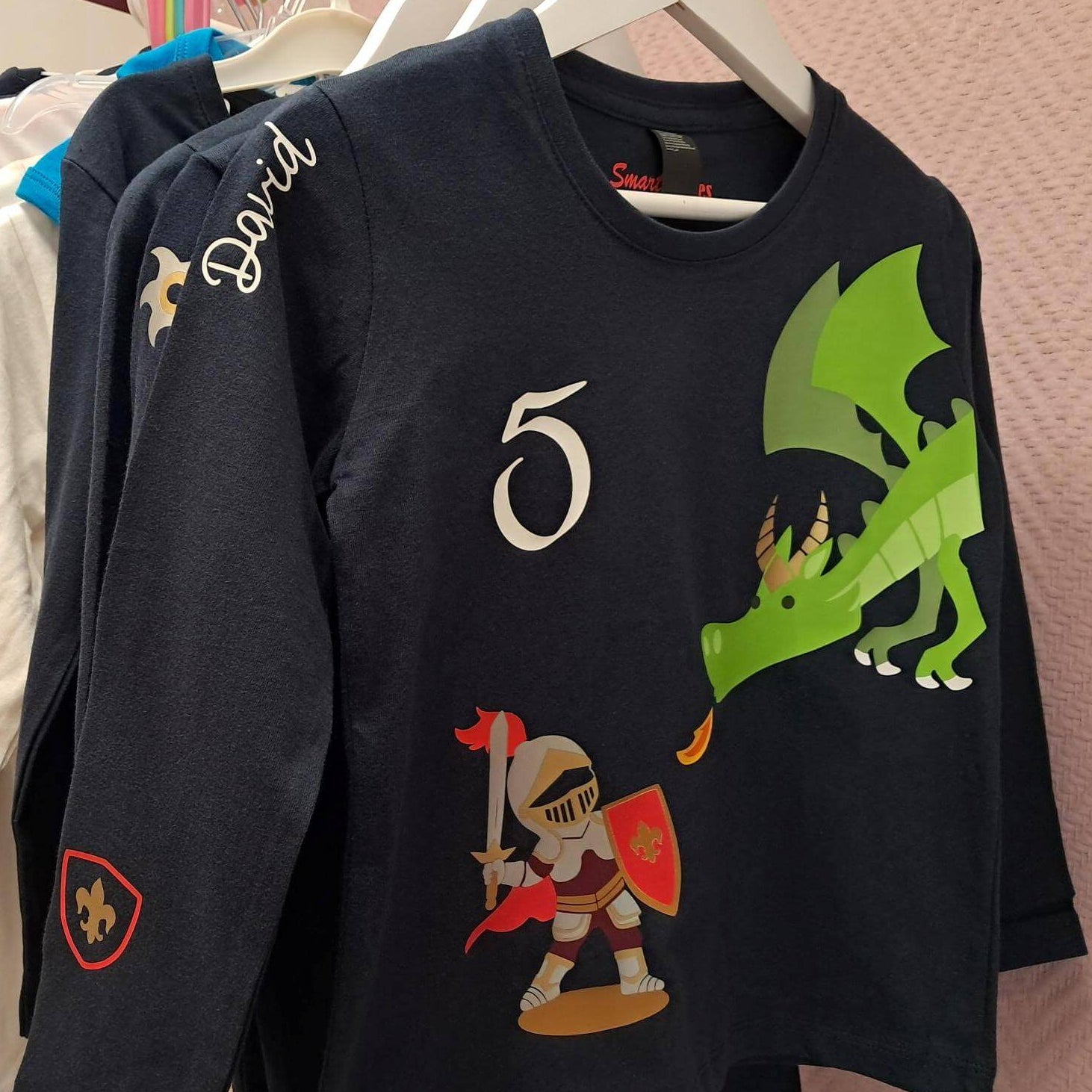 Geburtstagsshirts von Smartbabies mit Name und Zahl für Kinder Ritter und Drache auf Kleiderstange