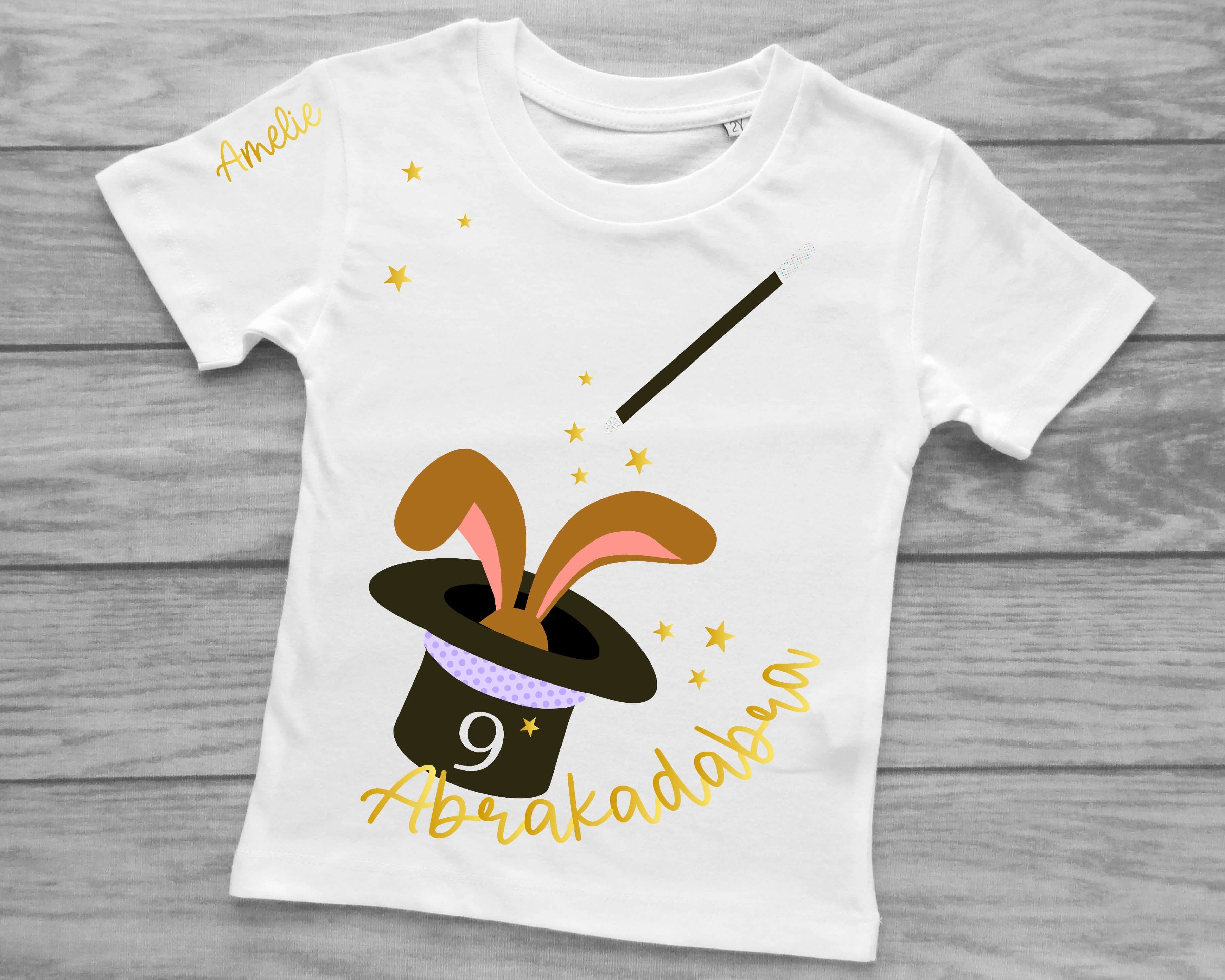 weißes Kinder-T-Shirt mit Zauberhut und Hase, magischem holographischem Effekt bedruckt, mit Name und Zahl