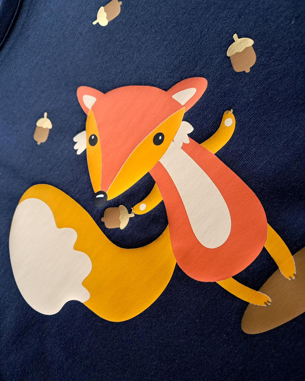 Detailansicht Aufdruck, navi farbenes Geburtstagsshirt für erste Geburtstage, bedruckt mit süßem Fuchs, der Eicheln jongliert und herbstlicher Szene
