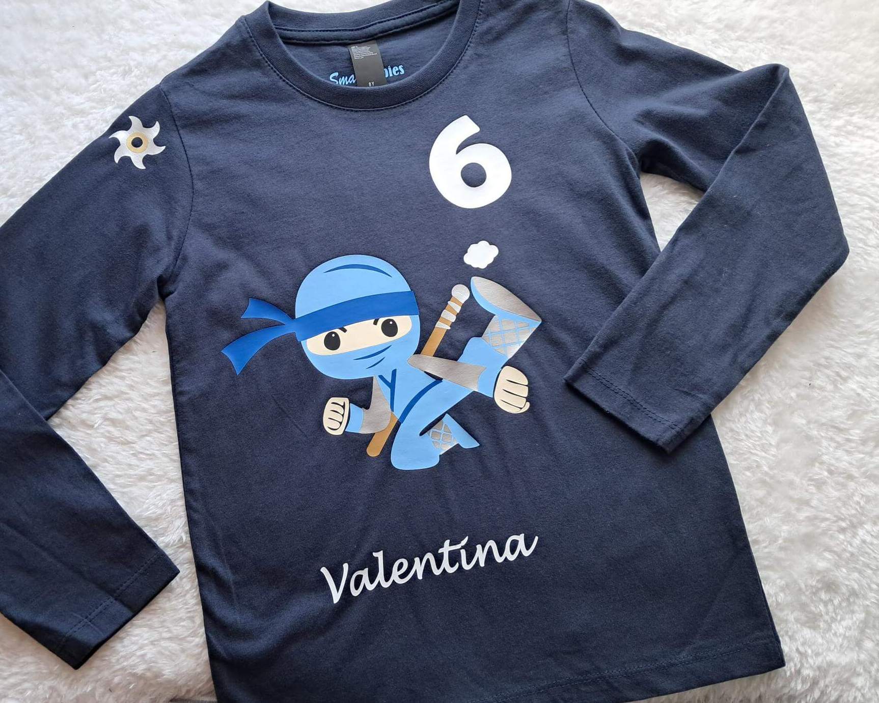 Liegebild navi Geburtstagssshirt für Kinder mit Ninja Kämpfer, Zahl und Name bedruckt, silber metallic Effekt
