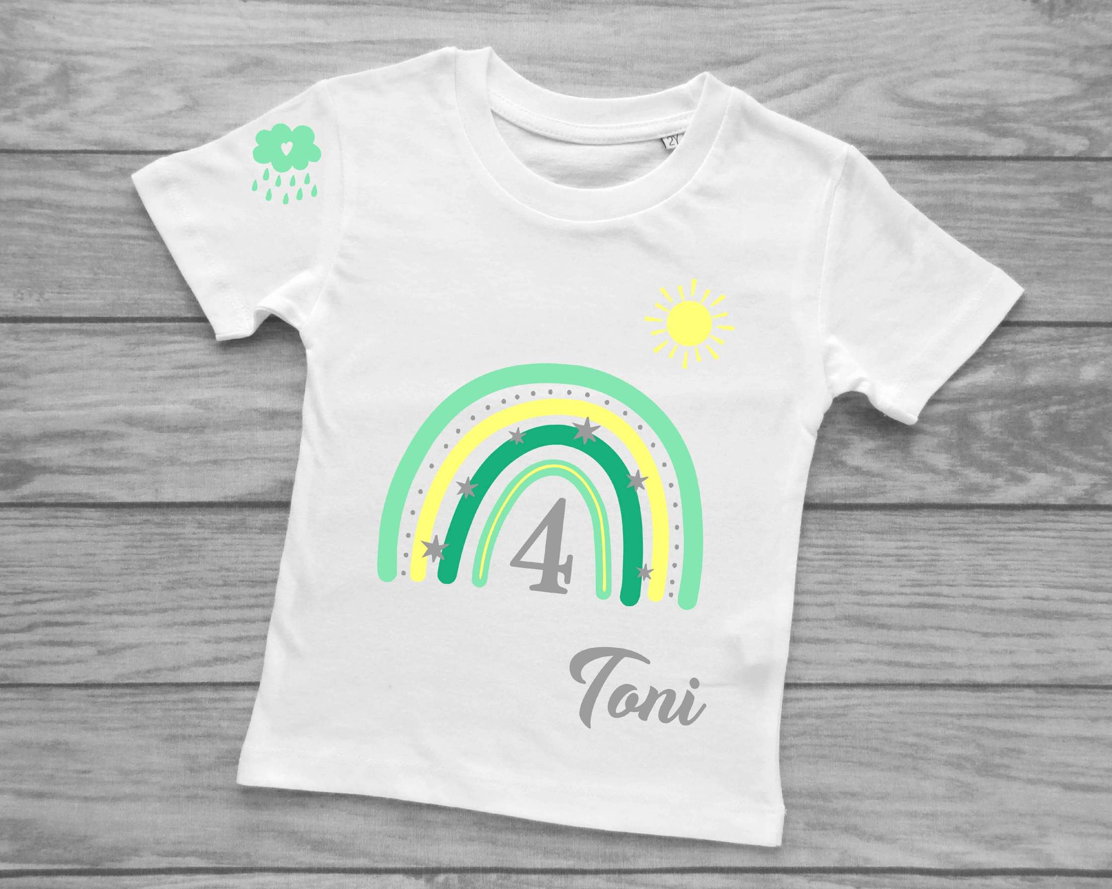 Kinder-Kurzarmshirt in weiß für Geburtstag mit pastell-mint Regenbogen, Name und Zahl, Sonne und Wolke bedruckt