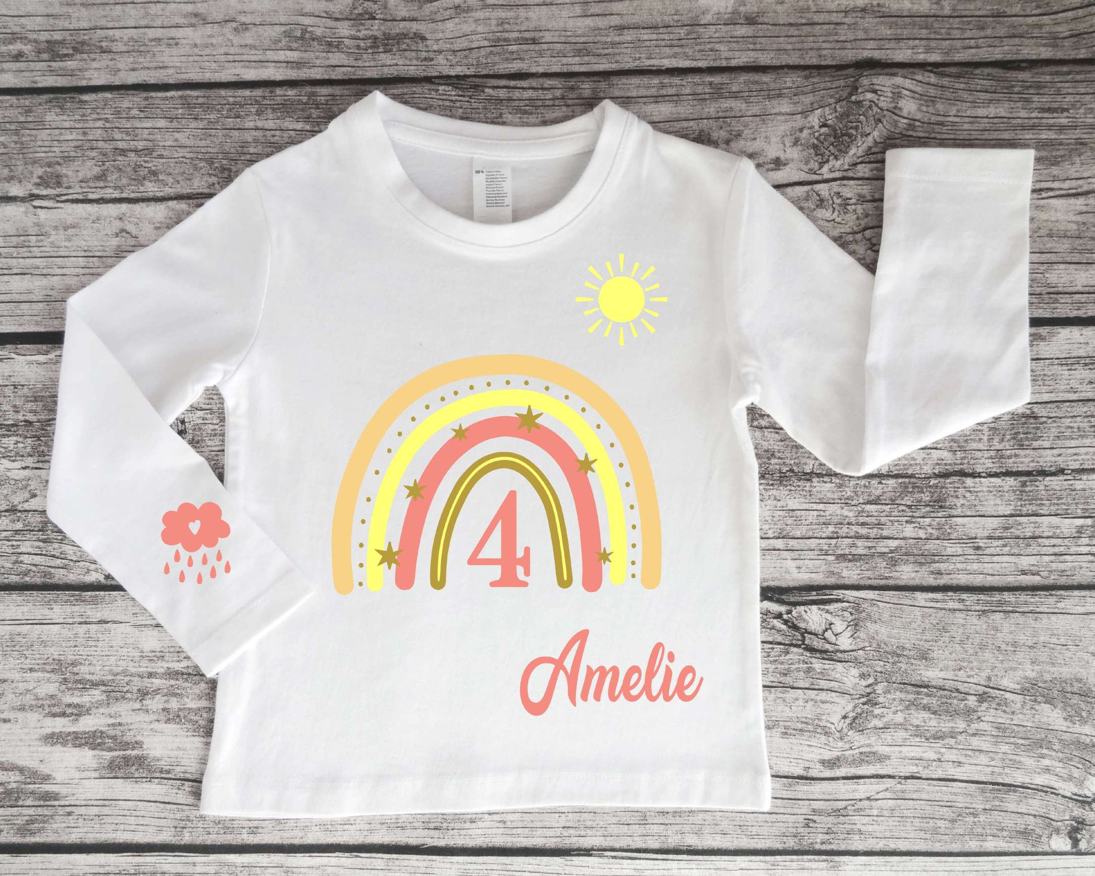 Kinder-Langarmshirt in weiß für Geburtstag mit pastell-rosa Regenbogen, Name und Zahl, Sonne und Wolke bedruckt