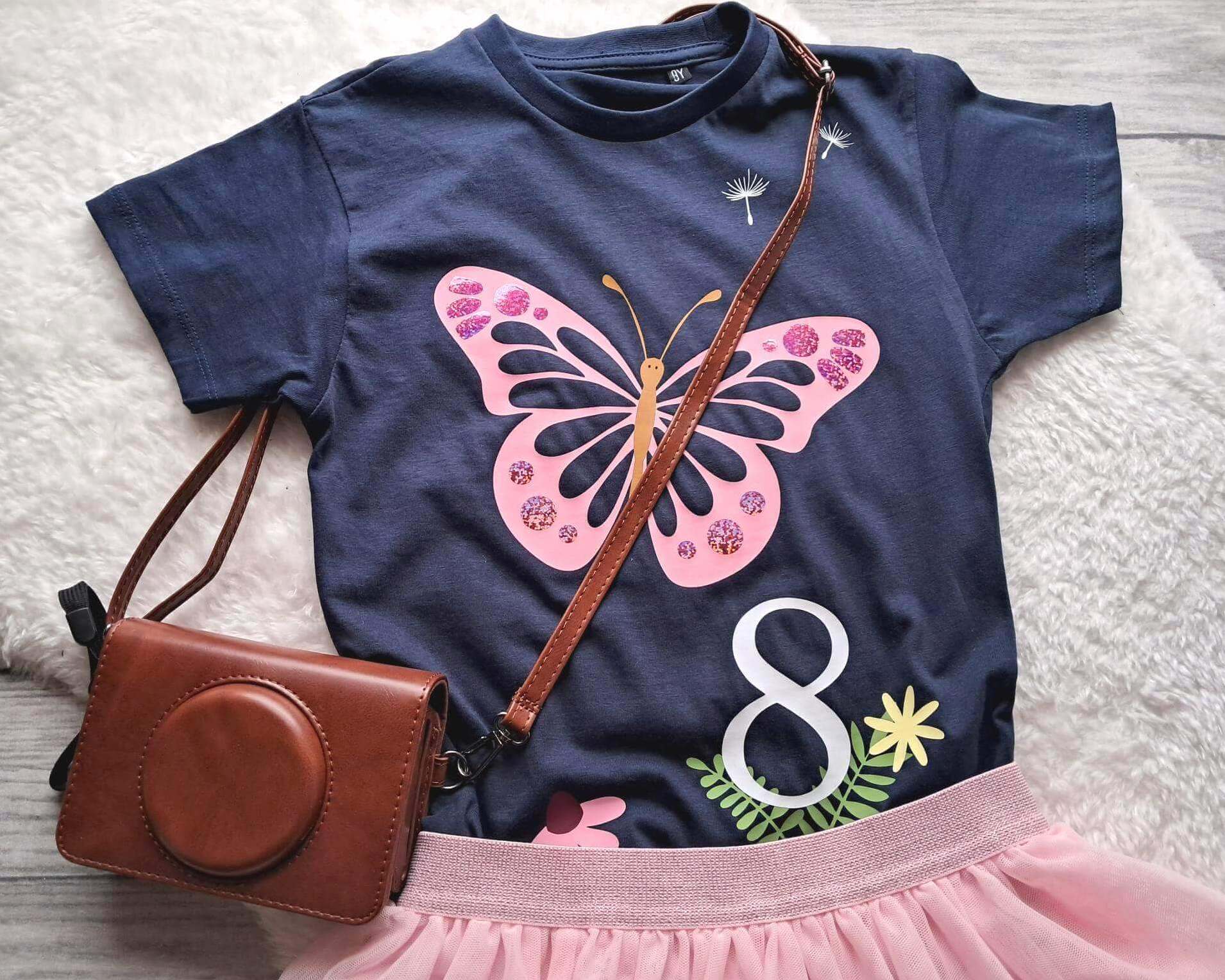 Tragebeispiel T-Shirt in french Navi für Geburtstagskinder, mit rosa Schmetterling frühlingshaft bedruckt, Blumen und Natur und holographischem glitter Effekt