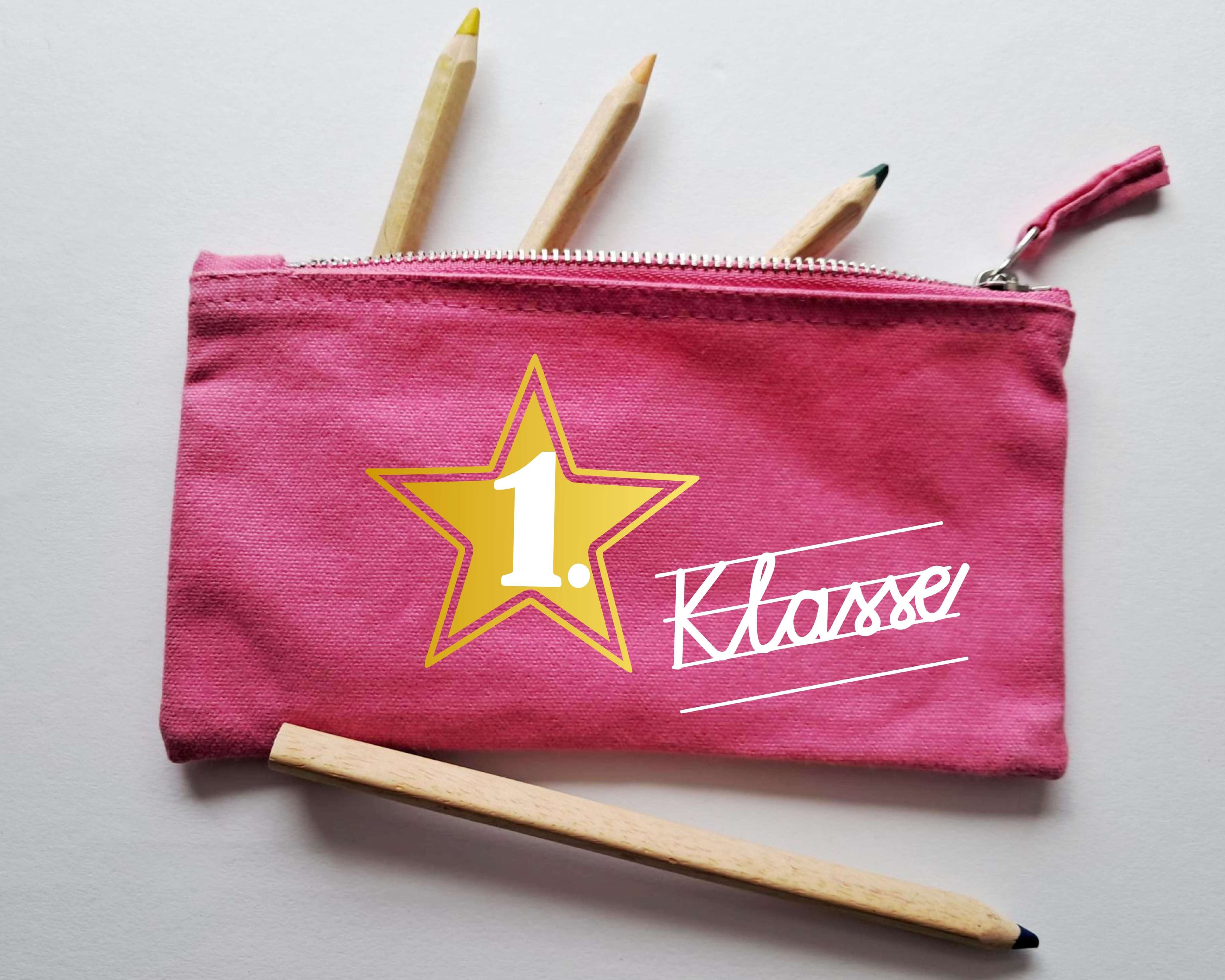 pinkes Stiftemäppchen mit Reißverschluss, bedruckt mit 1. Klasse in Schreibschrift in weiß und gold metallic Stern