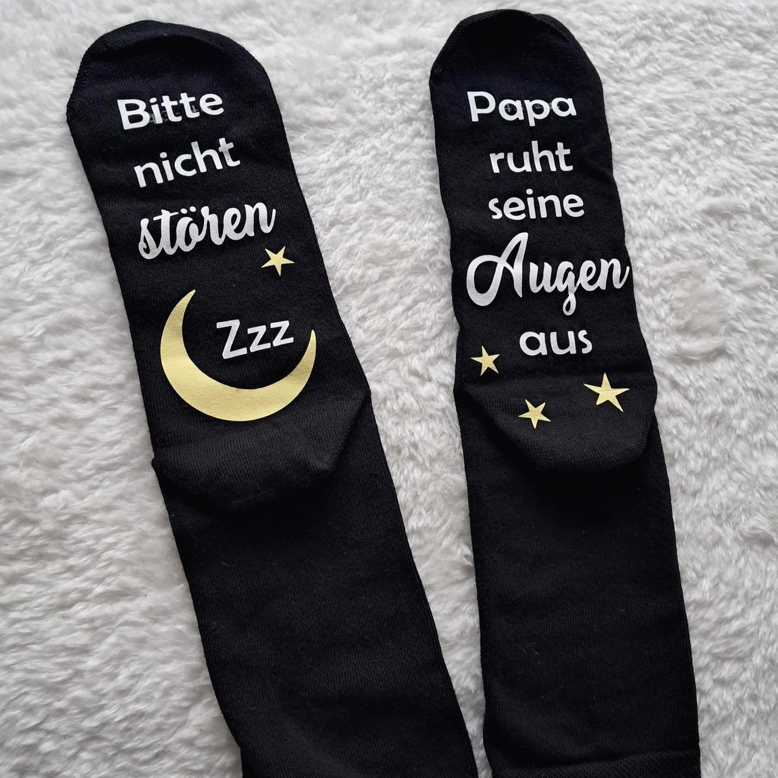 liegende schwarze Socken, bedruckt unter der Fußsohle mit Bitte nicht stören. Papa/Mama ruht sein/ihre Augen aus.