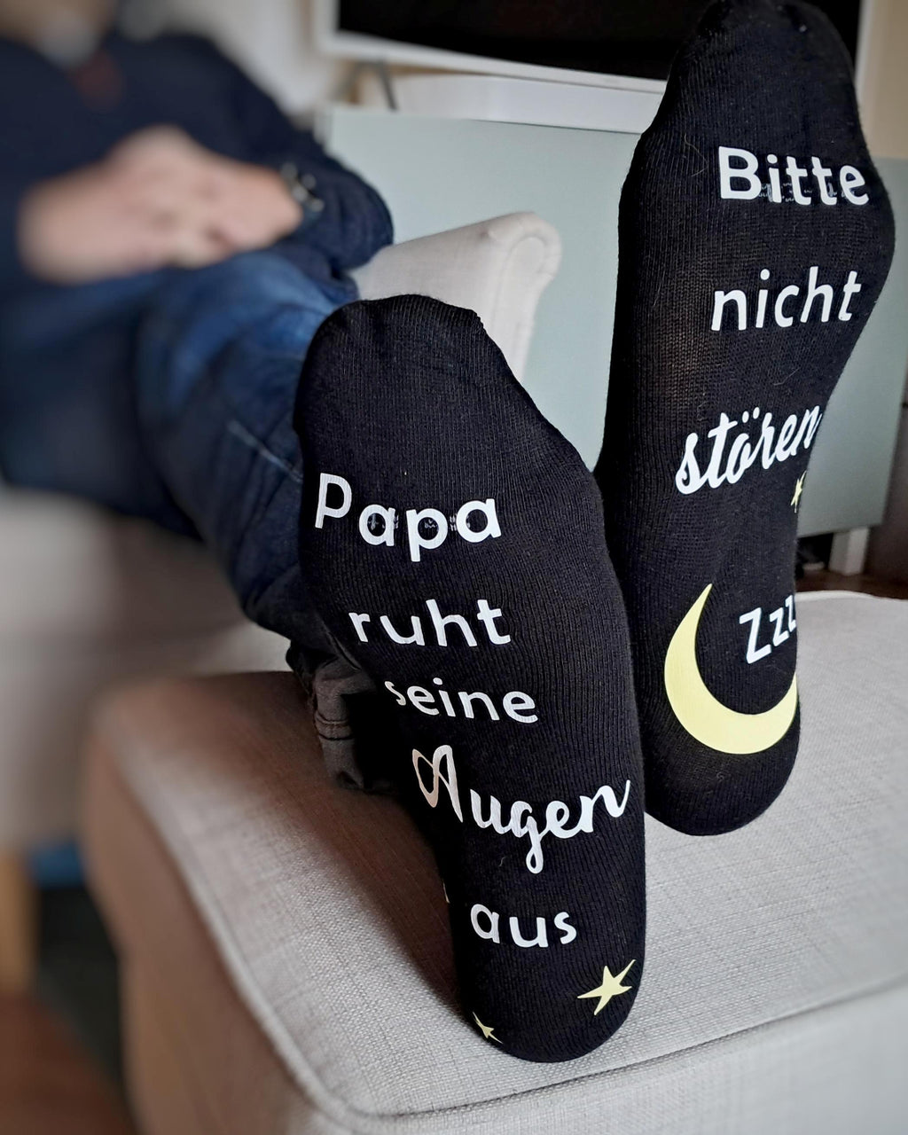 weitere Tragebild, Mann mit schwarzen Socken, bedruckt unter der Fußsohle mit Bitte nicht stören. Papa/Mama ruht sein/ihre Augen aus.