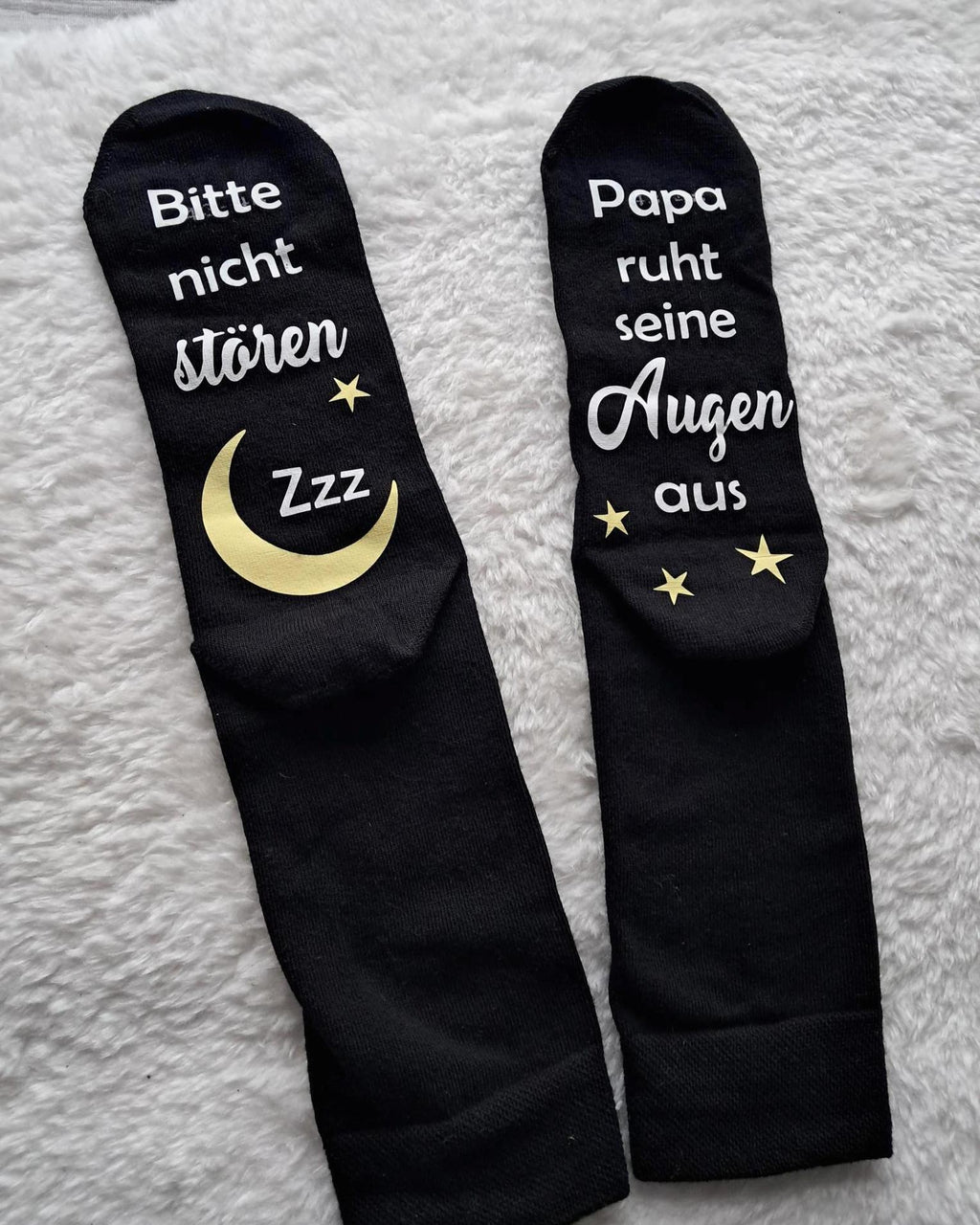 liegende schwarze Socken, bedruckt unter der Fußsohle mit Bitte nicht stören. Papa/Mama ruht sein/ihre Augen aus.