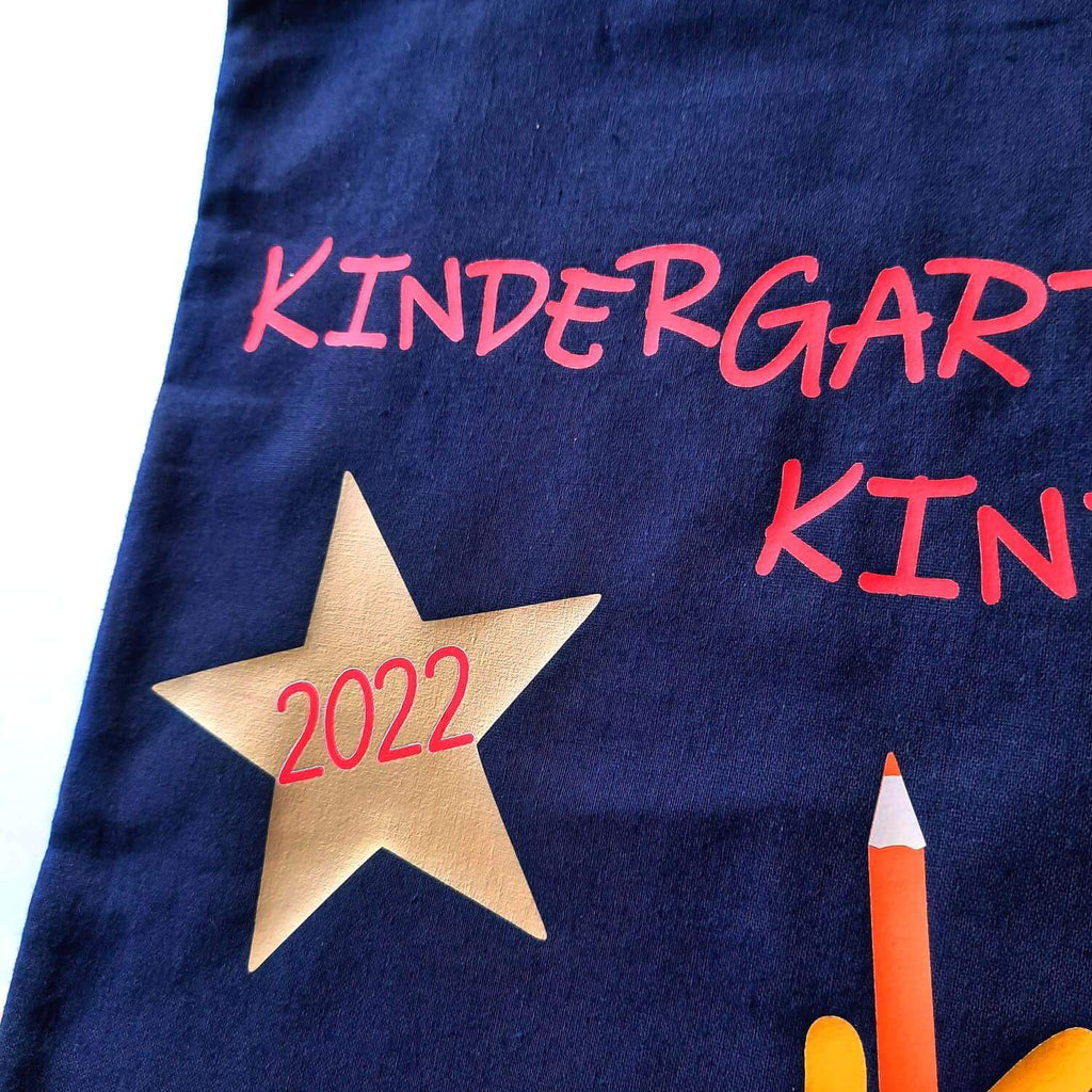 Detail goldener Stern auf Kindertasche, bedruckt mit Kindergartenkind und Name in rot für KITA-Anfang 